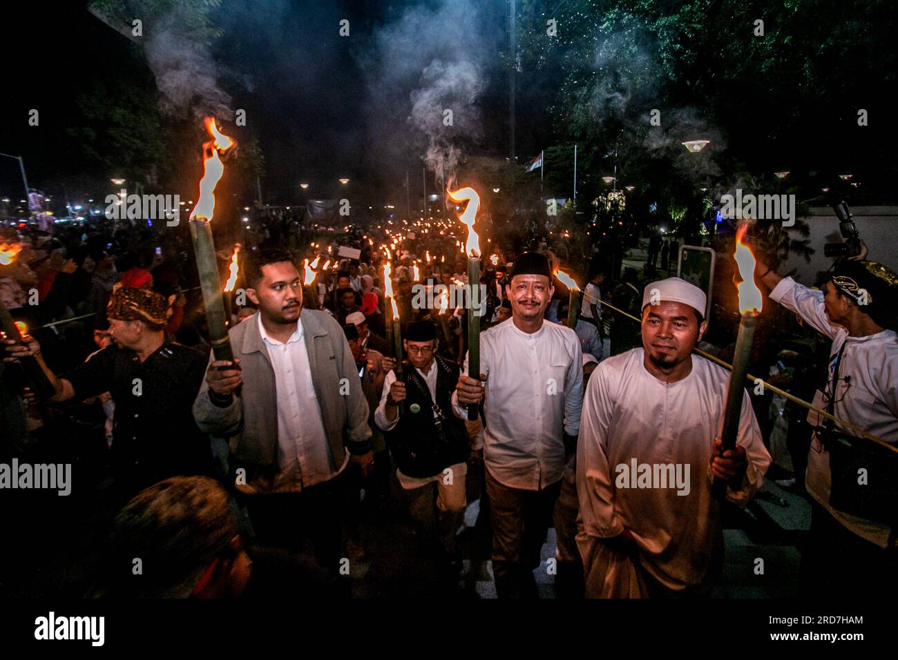 Muslims hold torches during a torch parade to celebrate the Islamic new year 1445 in