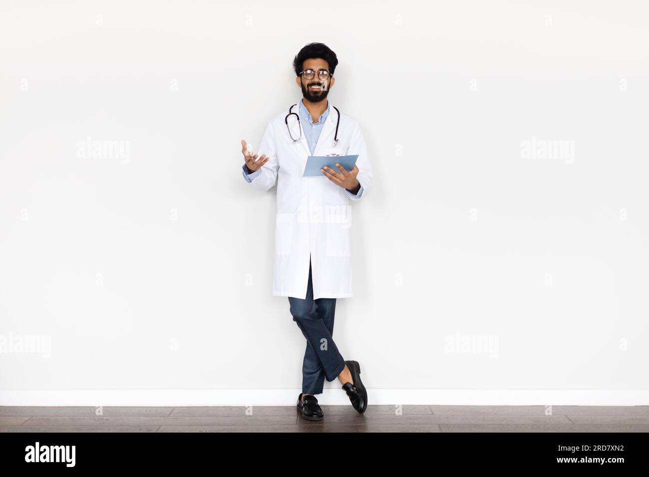Friendly young middle eastern doctor posing on white background Stock Photo