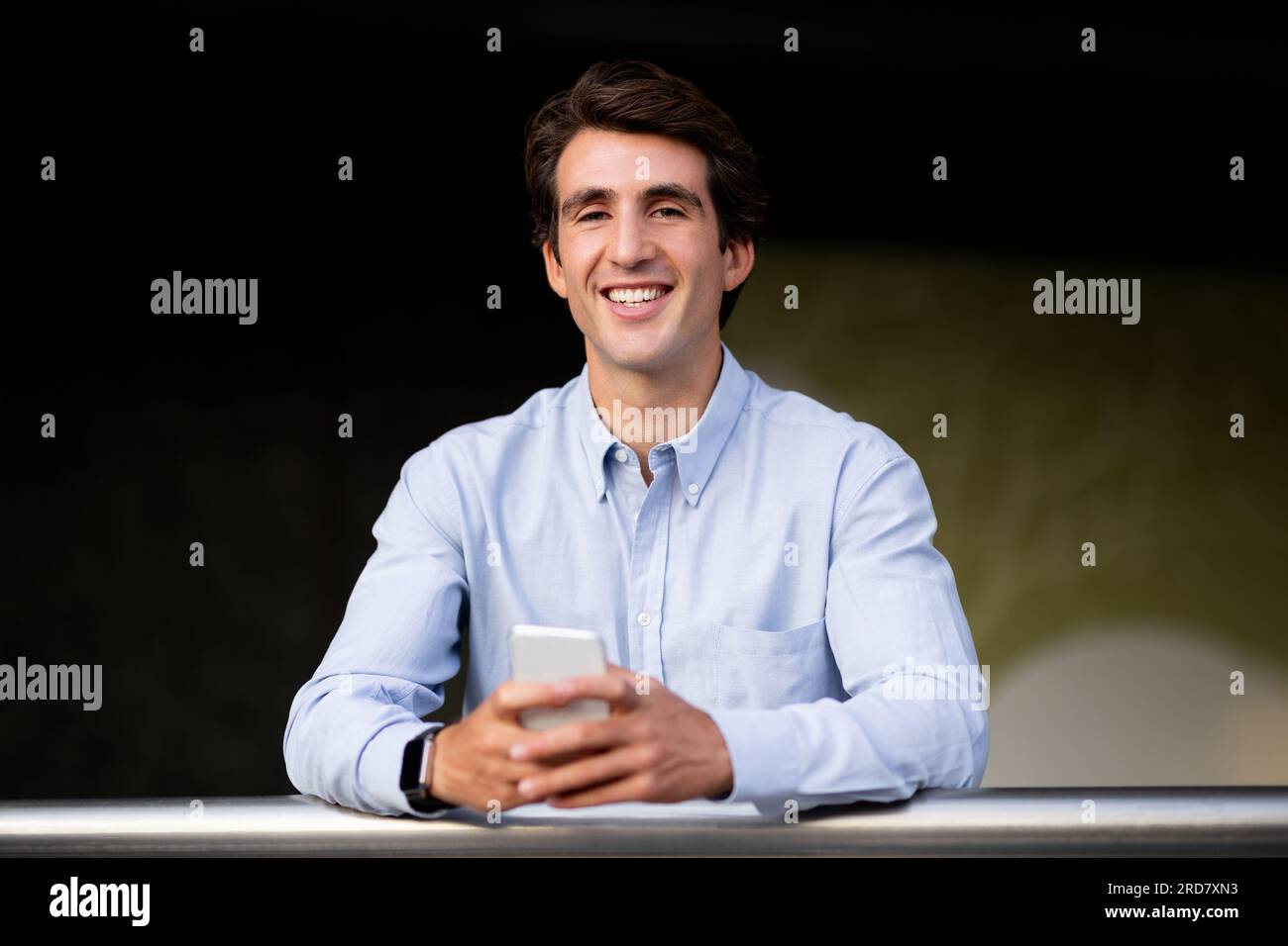 Portrait of cheerful young man in formal using smartphone Stock Photo