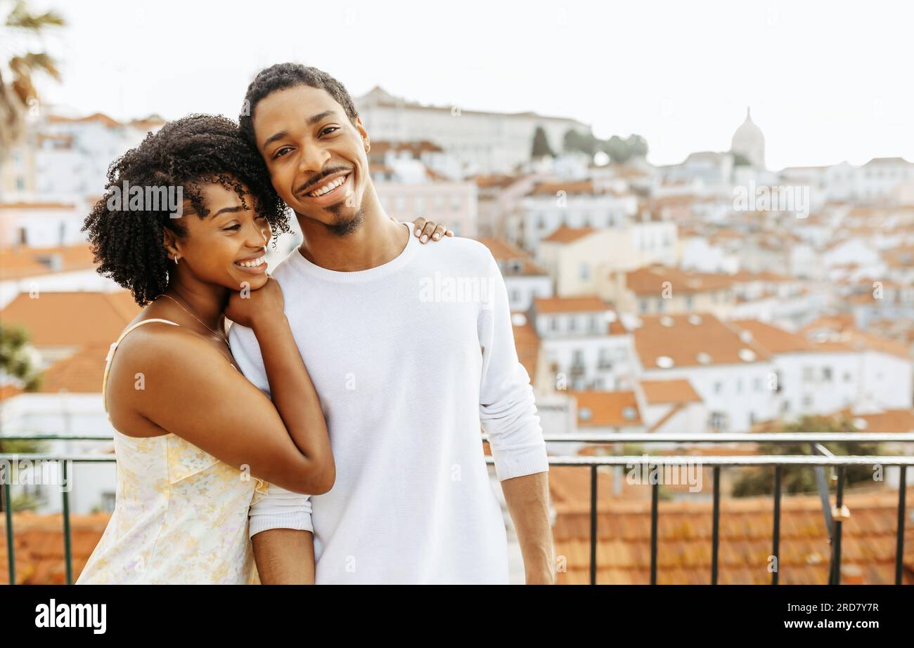Cheerful young african american woman hugging man in city, enjoy date ...