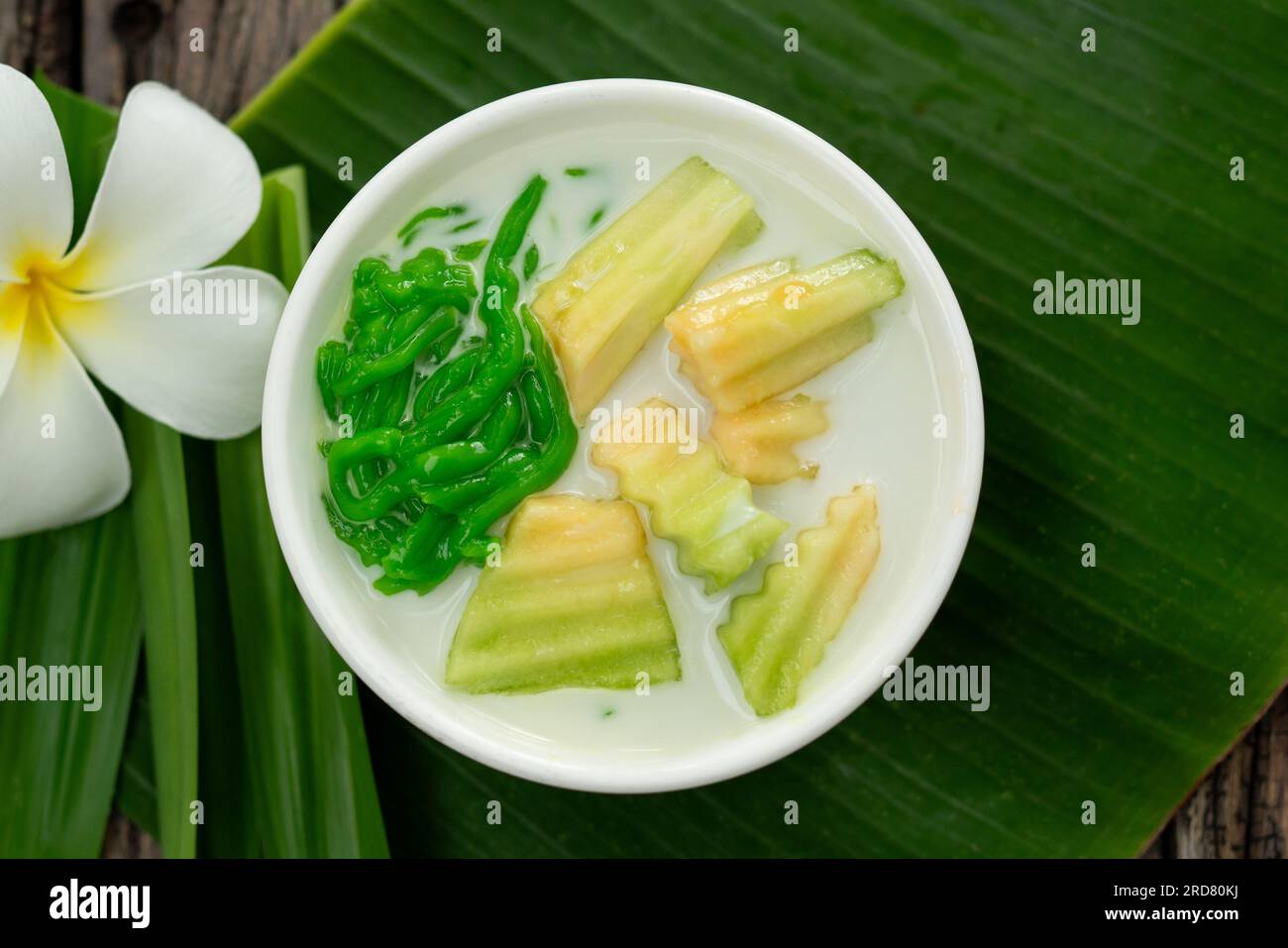 Top view of Thai dessert with pandan leaf followed by green banana leaves on the wood background. Stock Photo