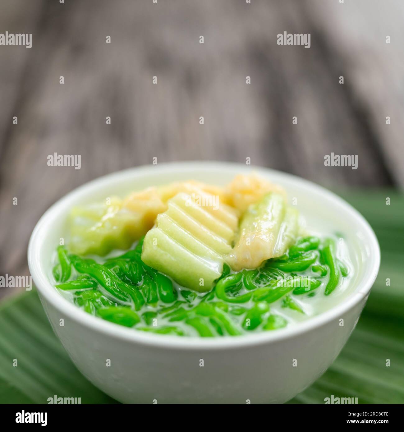 Close up of Lod Chong Thai dessert made from rice flour on top coconut syrup and pandan leaf on the wood background. Stock Photo