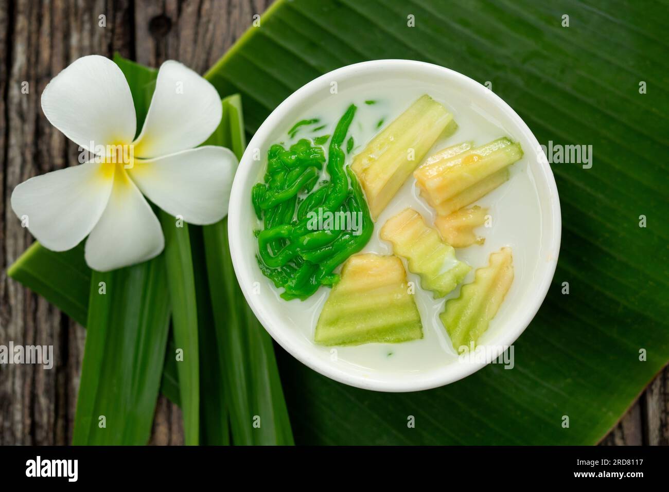 Lod Chong of Thai dessert with pandan leaf followed by green banana leaves on the wood background. Stock Photo