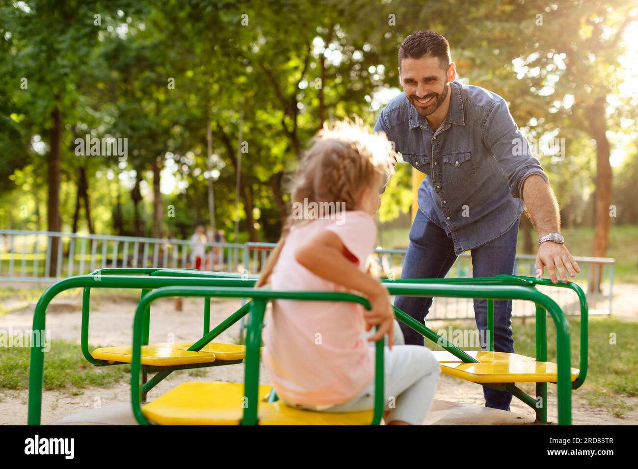 Child girl having fun with her father on outdoor playground, dad riding  daughter on carousel, spending time together Stock Photo - Alamy