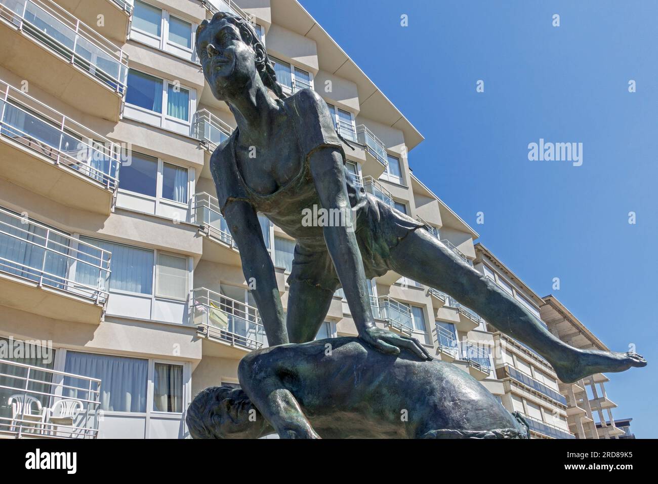 Statue Haasje Over on the sea dyke and flats / apartments at seaside resort Koksijde / Coxyde along the North Sea coast, West Flanders, Belgium Stock Photo
