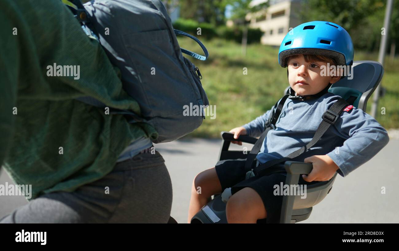 Child in the back seat of bicycle riding with mother kid in bike back