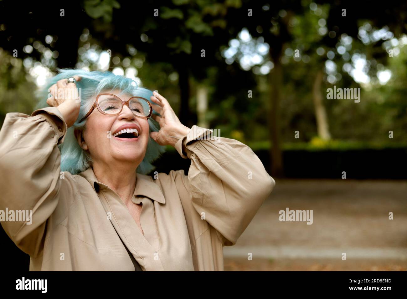 older woman with blue hair very happy outdoors Stock Photo
