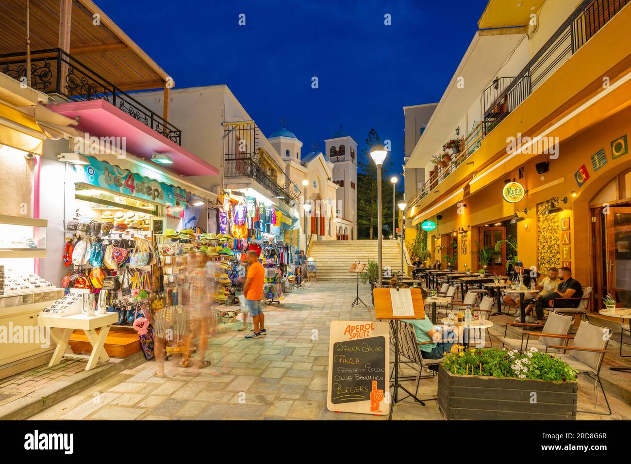 View of shops and restaurants with Church of Agia Paraskevi in the background in Kos Town at dusk, Kos, Dodecanese, Greek Islands, Greece, Europe Stock Photo