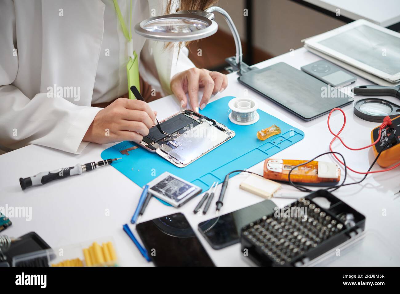 Technician using tweezers when repairing smartphone Stock Photo