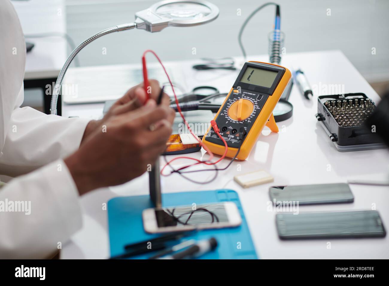 Engineer using multimeter when examining if smartphone works good after repairing Stock Photo