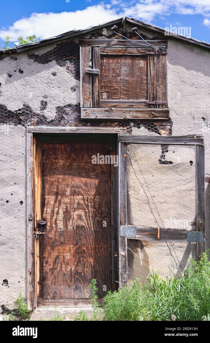 Old storage shed stands weathered with hay loft door above lower door ...