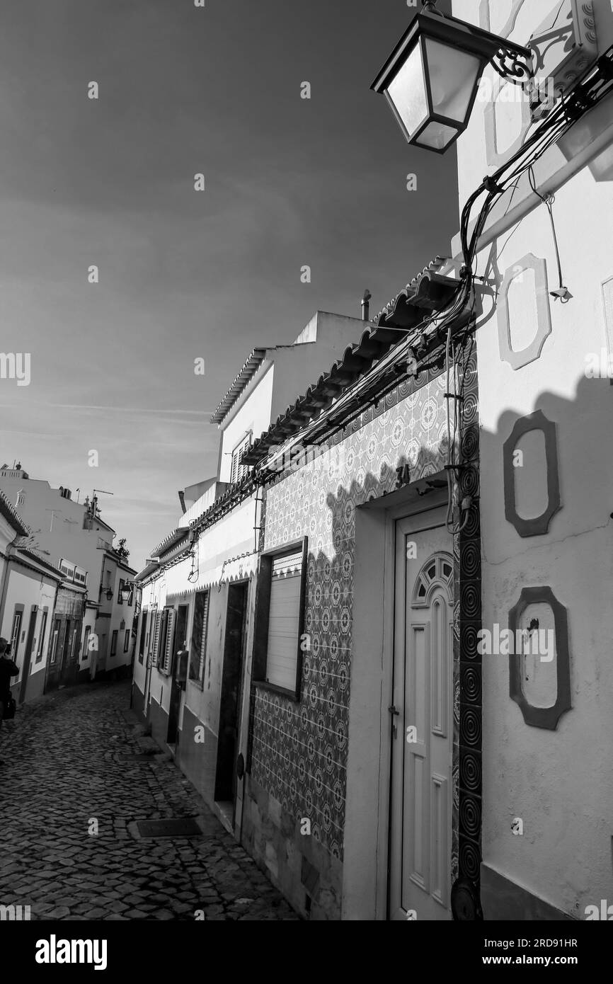 Ferragudo, Portugal- October 20, 2022: Narrow Cobblestone streets and typical Portuguese facades in Ferragudo town, Portugal Stock Photo