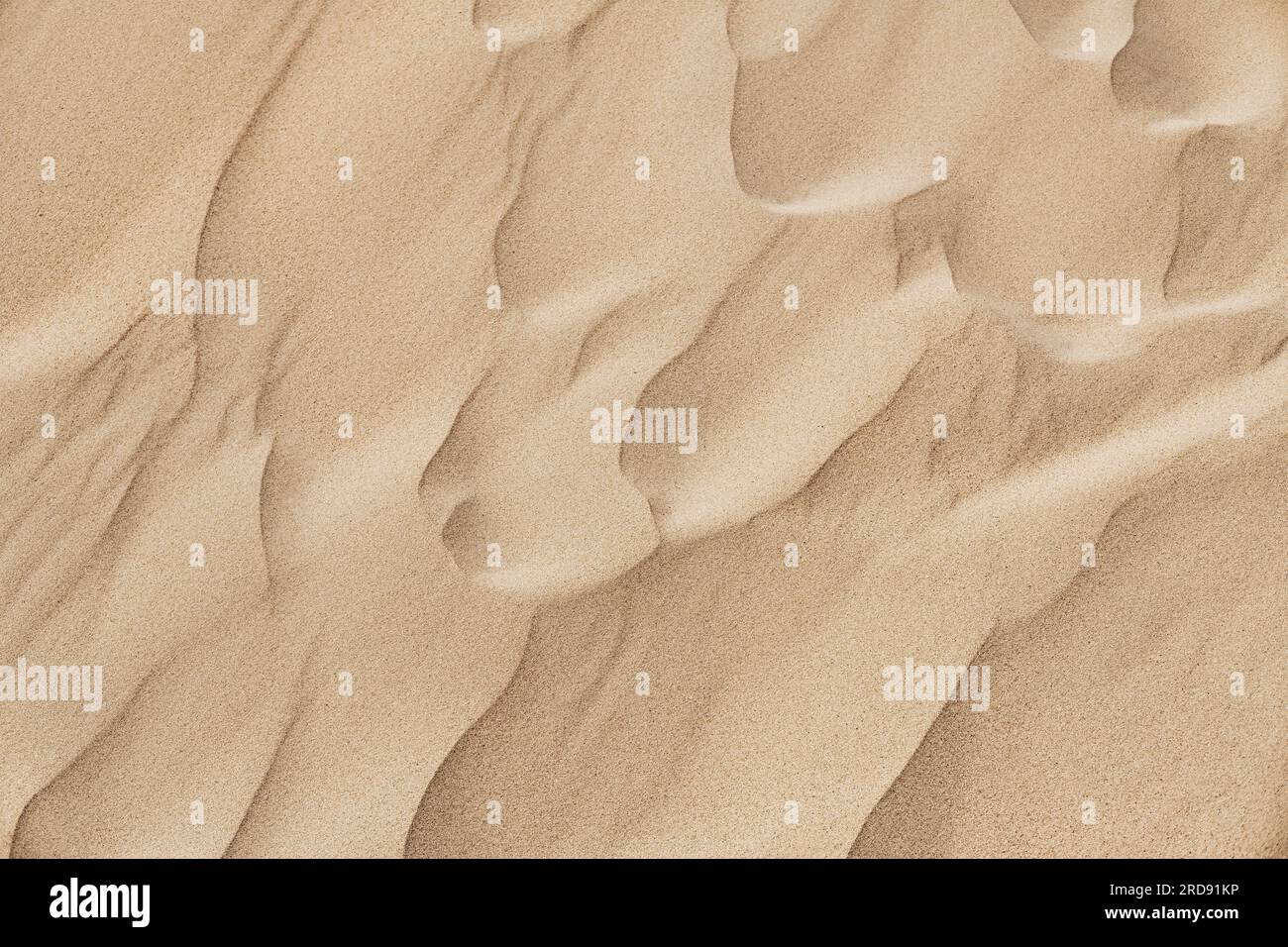 Natural sand texture. Yellow sand on the beach. Wavy sand background for summer designs. Stock Photo
