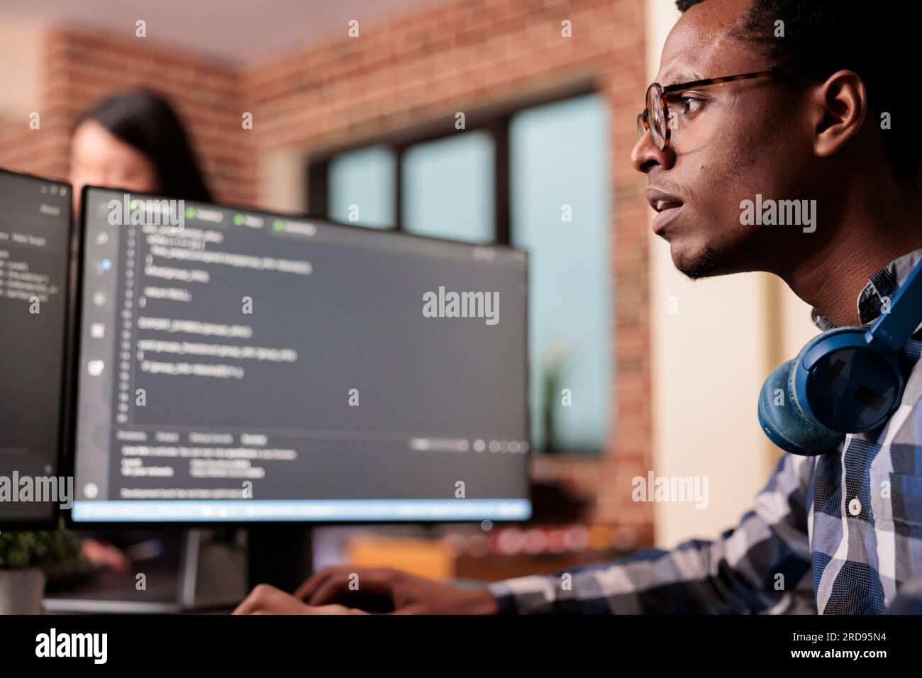 System engineer typing machine learning server code on computer, sitting at desk in software company. Programming engineer working on database system with coding script in it security agency. Stock Photo
