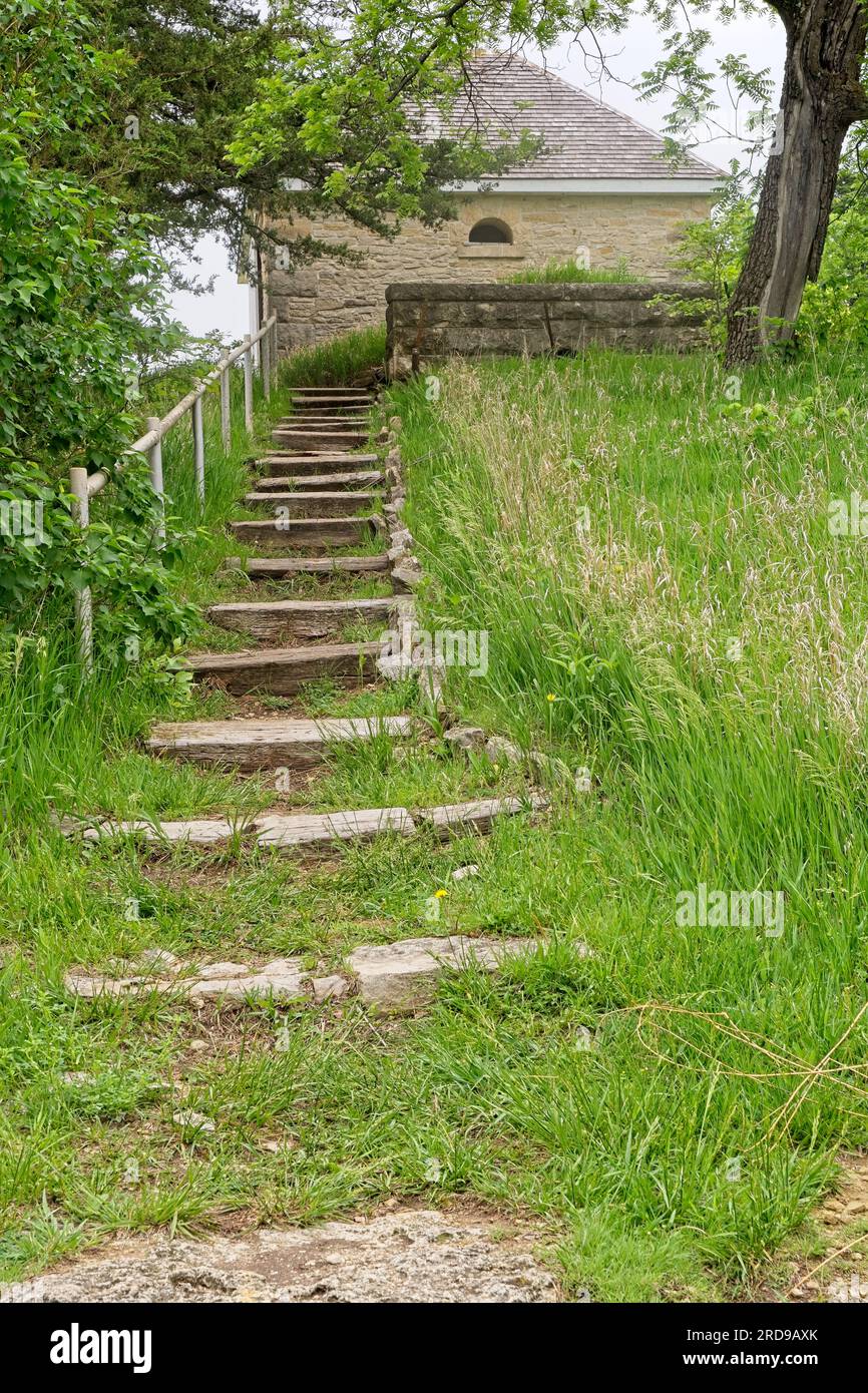 Wooden hewn timber steps climb hill towards limestone ice house at
