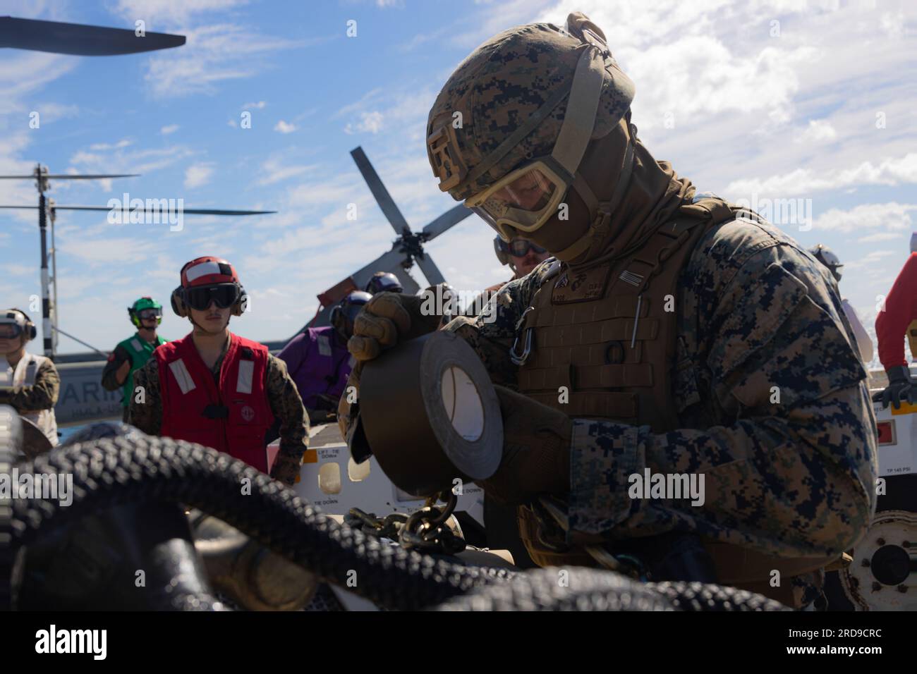 U.S. Marine Corps Cpl. Jacob Wyman, a landing support specialist with Combat Logistics Battalion 31, 31st Marine Expeditionary Unit, secures supplies in place during a real-life helicopter support team  aboard the amphibious transport dock ship USS Green Bay (LPD-20) in the Coral Sea, July 1, 2023. The HST was in support of establishing a forward arming and refueling point for real-life training and sustainment. Wyman is a native of Plaistow, New Hampshire. The 31st MEU is operating aboard ships of the America Amphibious Ready Group in the 7th Fleet area of operations to enhance interoperabili Stock Photo