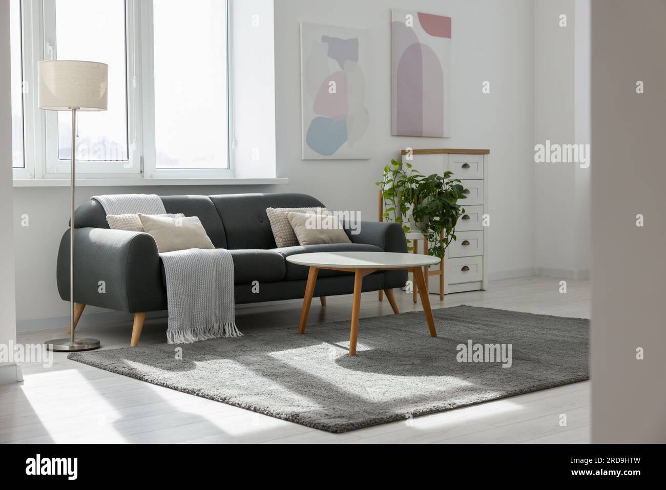 Stylish living room with gray couch, white coffee table and lamp ...