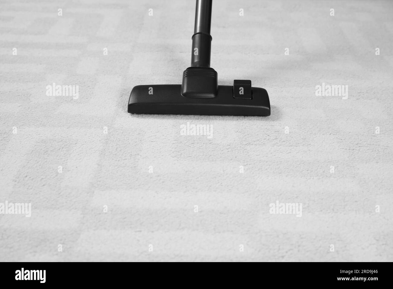 Removing dirt from white carpet with modern vacuum cleaner. Space for