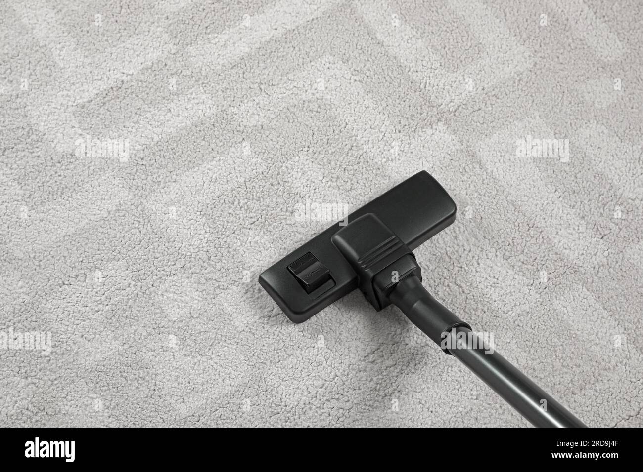 Removing dirt from white carpet with modern vacuum cleaner, above view