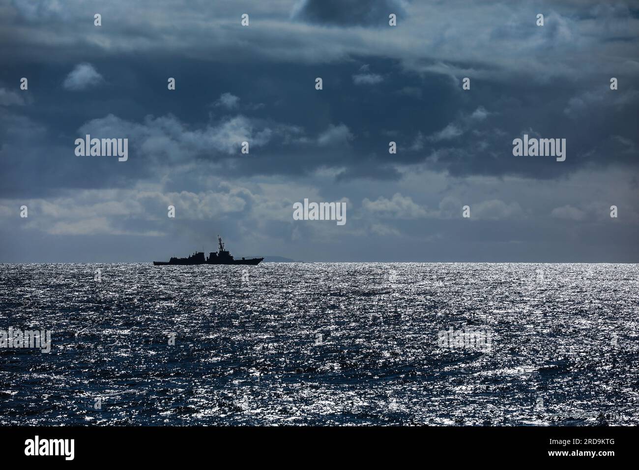 Silhouetted on the horizon one of the mainstay of the US Navy escort fleet an Aerleigh Burke class destroyer, with 90 planned and over 70 in service Stock Photo