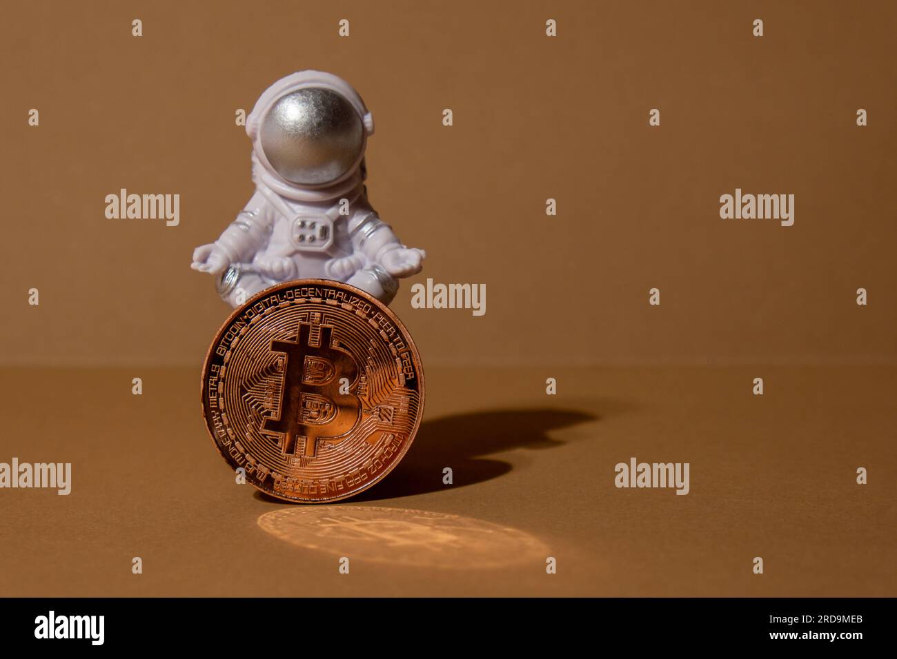 Plastic toy astronaut holding Bitcoin gold coin mining trading concept. BTC  golden money. Worldwide virtual internet Cryptocurrency or crypto digital  payment system. Concept of out of earth travel, private spaceman commercial  flights.