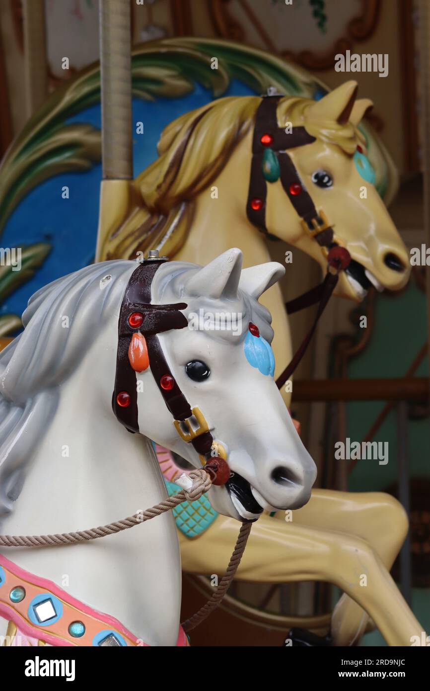 Close up of colourful traditional fairground galloper carousel horses, mounted on a Spanish fairground carousel on the harbour front at La Coruna. Stock Photo