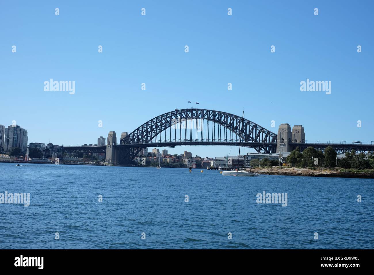 Sydney Harbour Bridge is seen from on the water to the west of Barangaroo, clear blue sky and beautiful blue water Stock Photo