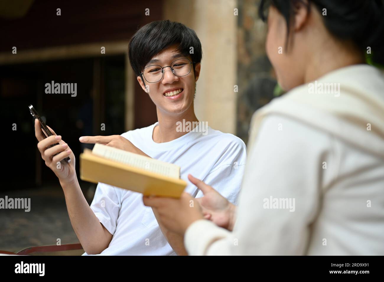 A happy young Asian male college student enjoys talking and chilling ...