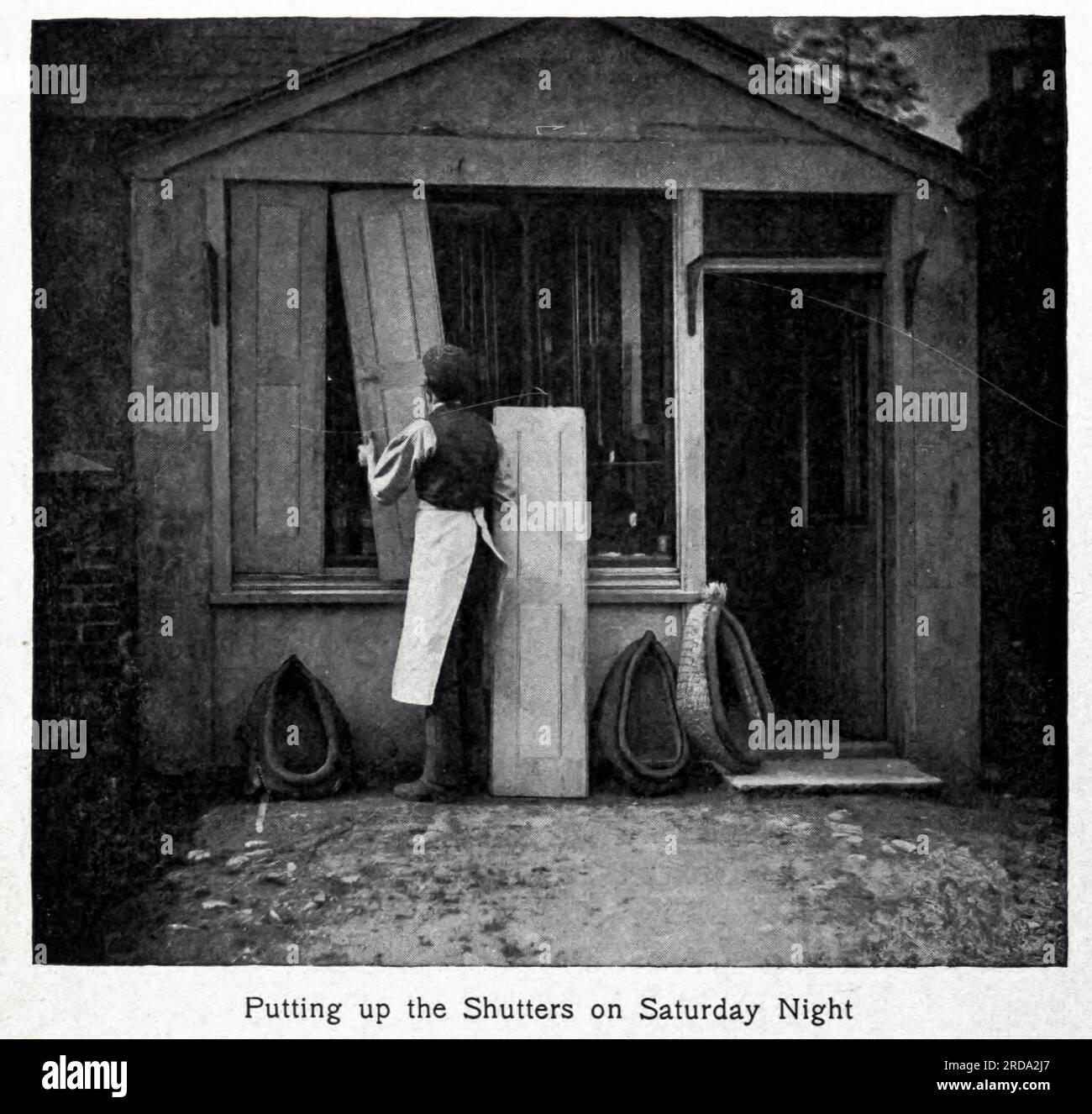 Putting up the Shutters on Saturday Night black and white photograph from the book '  Among English hedgerows ' by  Clifton Johnson, 1865-1940 Publication date 1899 reprinted in 1914 Publisher New York : The Macmillan co.; London, Macmillan and co., ltd. Stock Photo