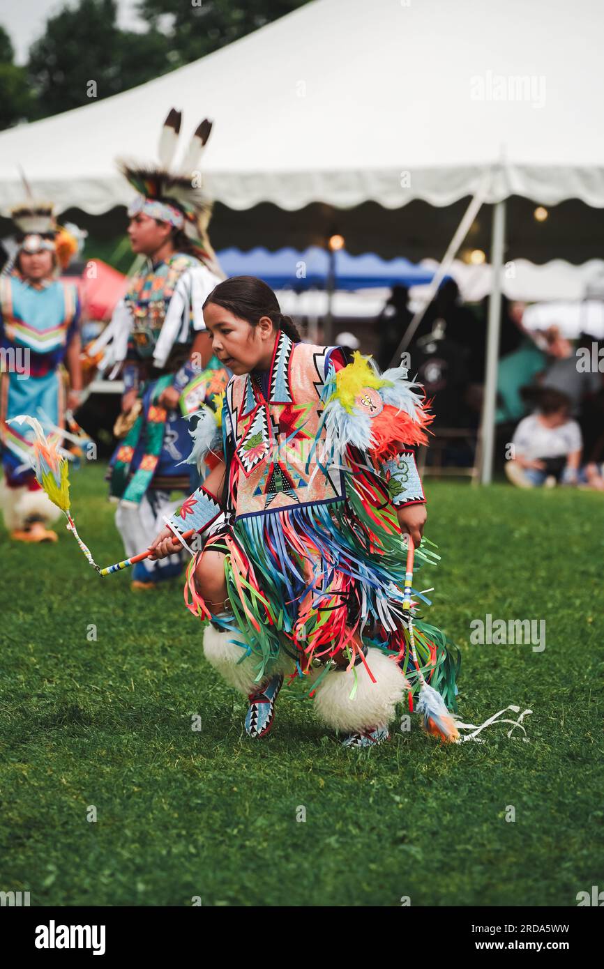 young native American boy dressed in colorful dancing outfit at pow wow event to celebrate indigenous culture Stock Photo