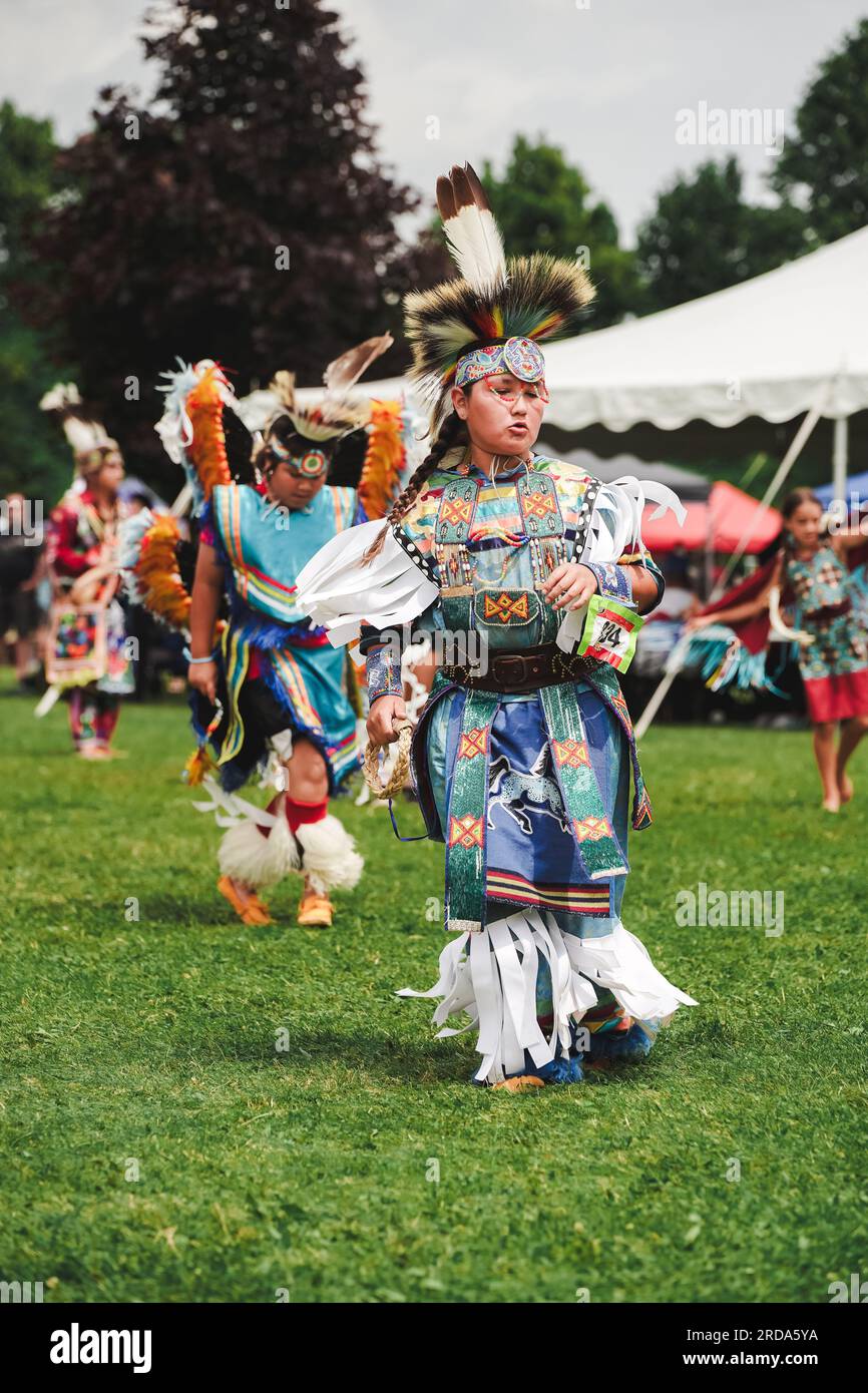 young native American boy dressed in colorful dancing outfit at pow wow event to celebrate indigenous culture Stock Photo