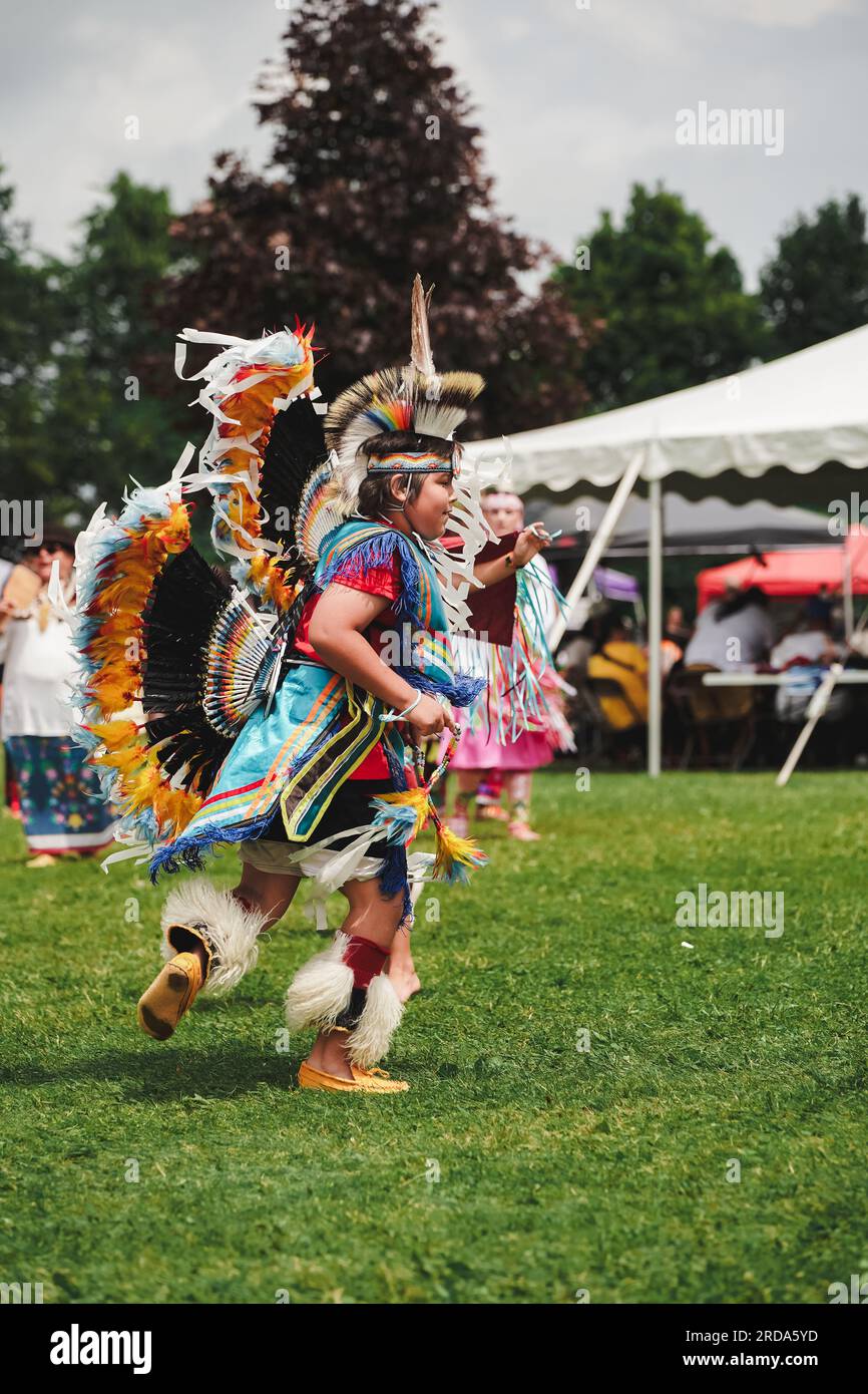 young native American boy dressed in colorful dancing outfit at pow wow