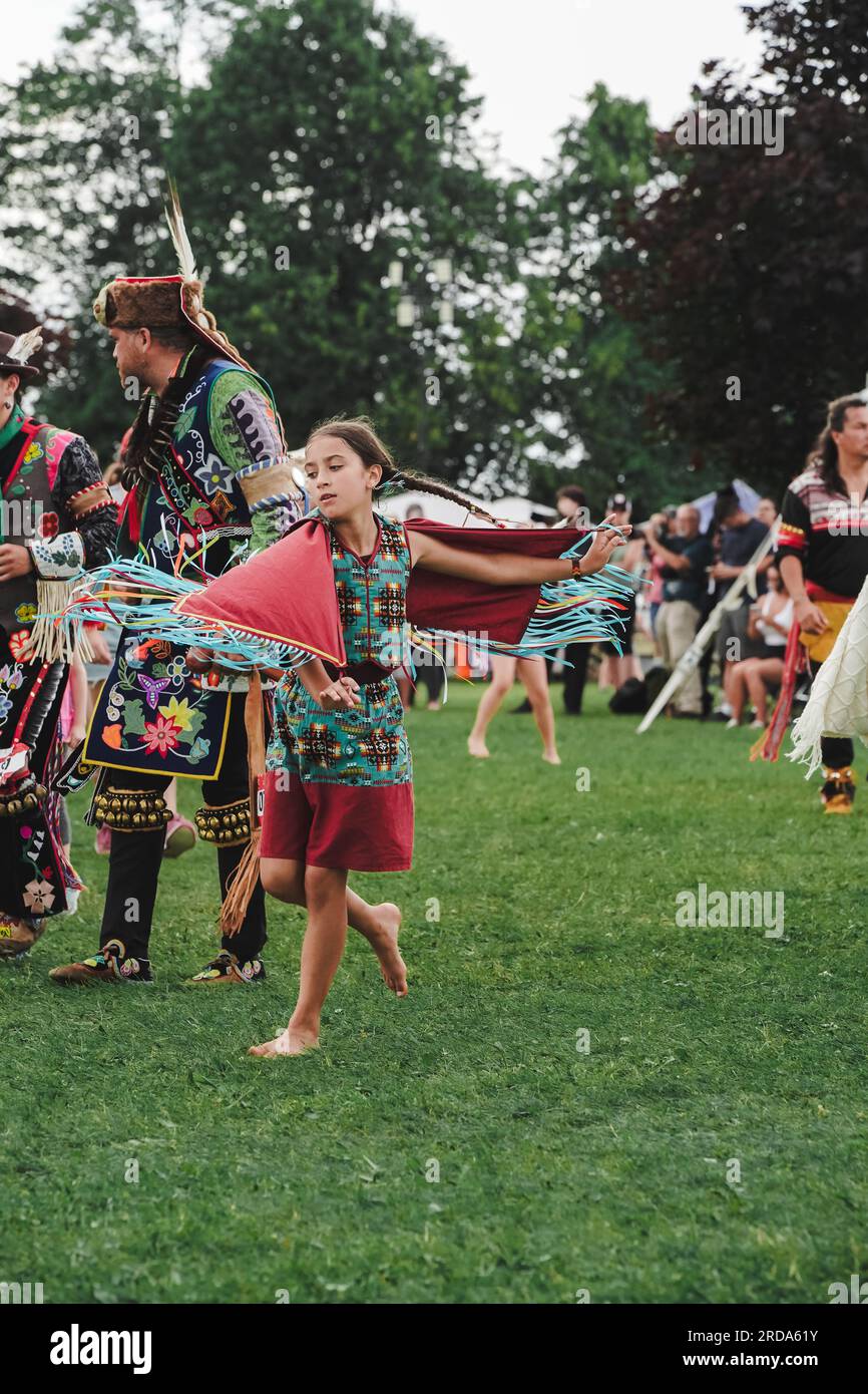a young native American girl in shawl outfit dancing at pow wow an event to celebrate indigenous culture Stock Photo