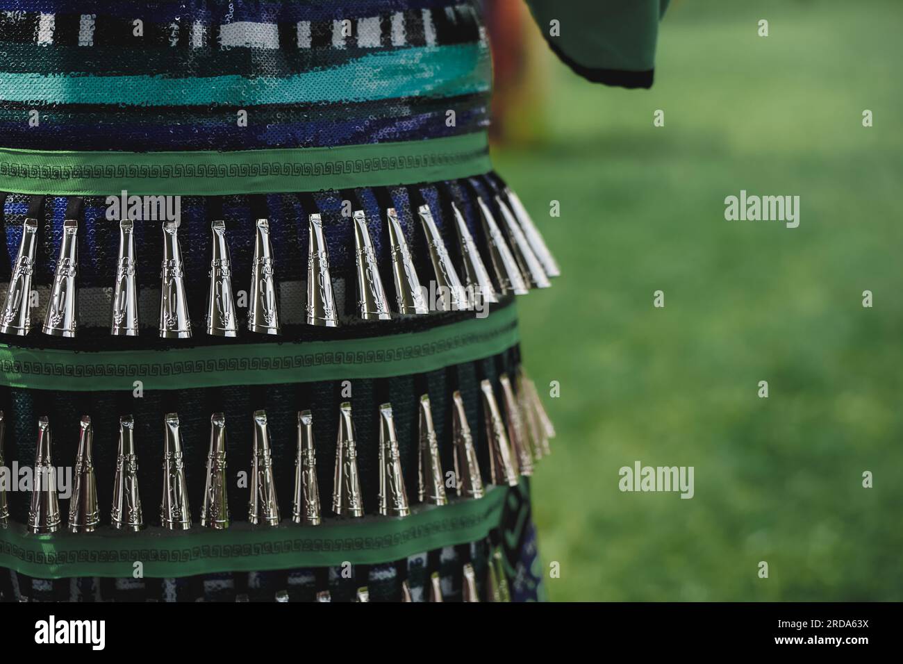 close up of decorative metal cones on a jingle dress worn by an anonymous native during pow wow