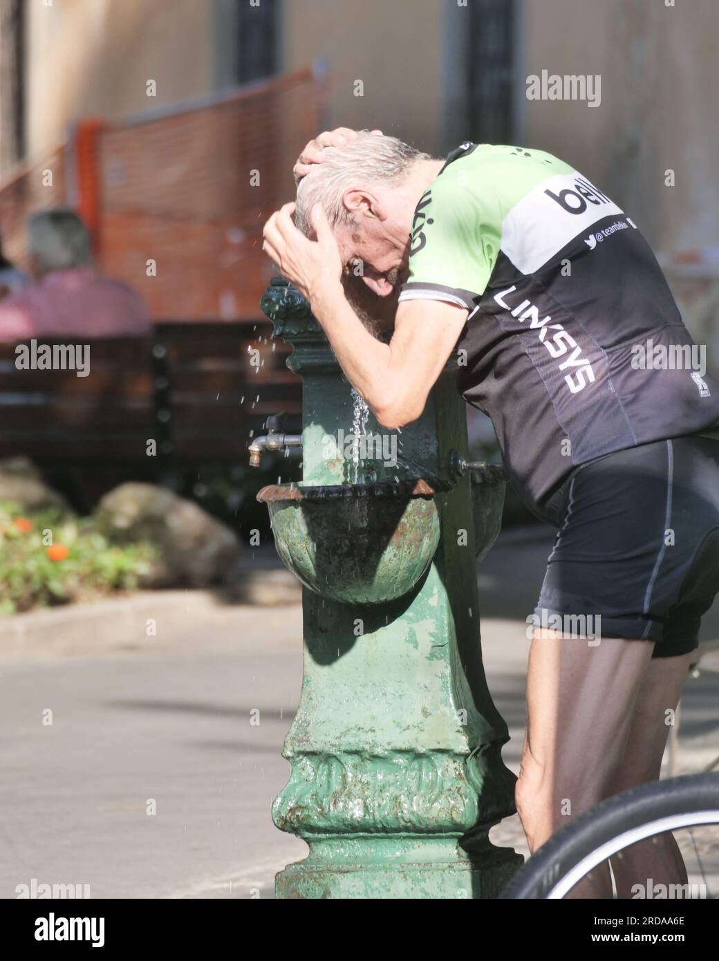Cyclist quenches his thirst with fresh water from a bottle Stock Photo