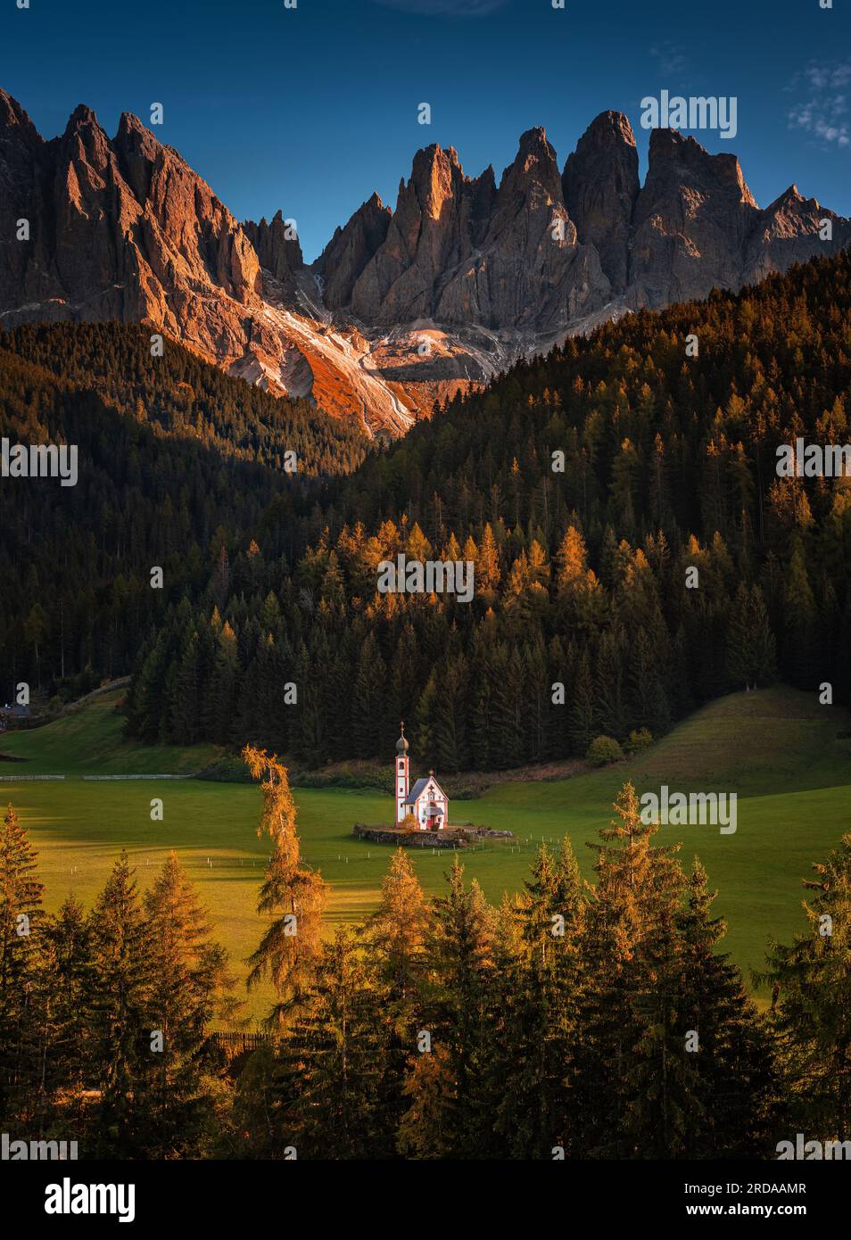 Val Di Funes, Dolomites, Italy - The beautiful St. Johann in Ranui Church at South Tyrol with the Italian Dolomites and blue sky at background with wa Stock Photo