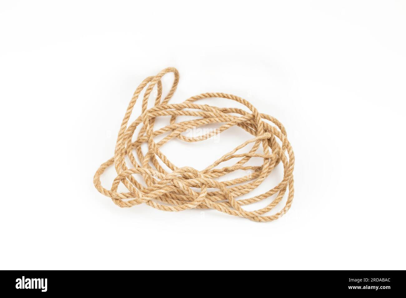 Loose tangled jute rope coil, isolated on white background Stock Photo