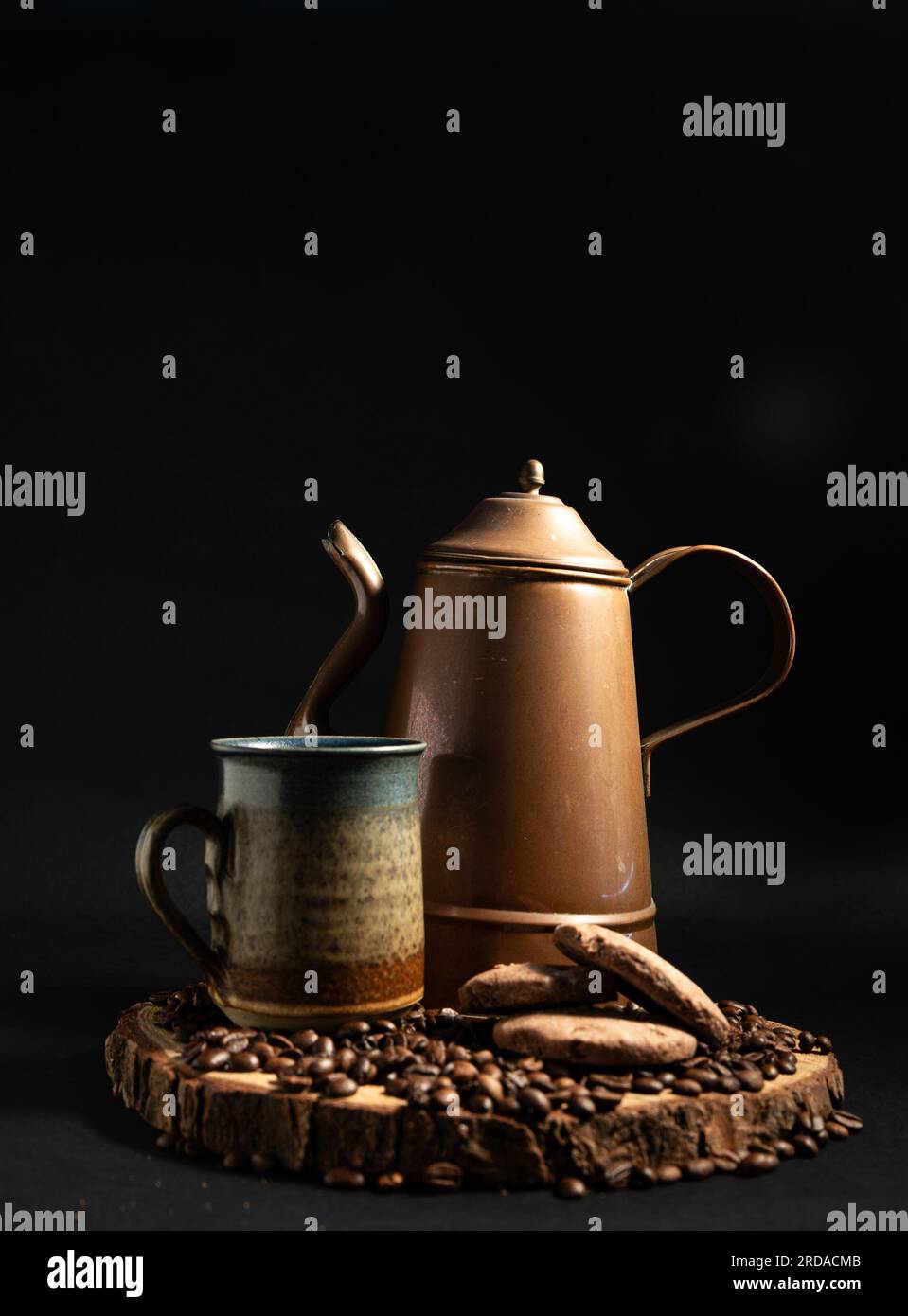 A copper coffee pot, ceramic mug, coffee beans and biscuits. Stock Photo