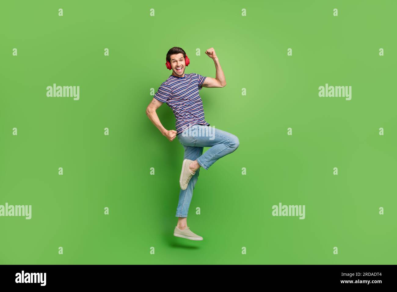Full length photo of funky lucky man dressed striped t-shirt jumping ...