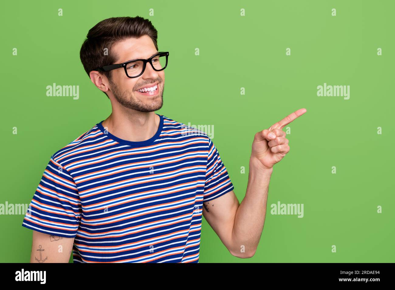 Photo of interested young guy wearing stylish t shirt indicate finger