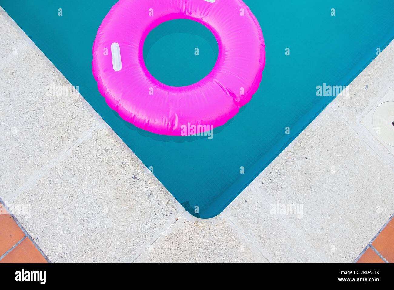 Bright pink float in blue swimming pool, close up view Stock Photo