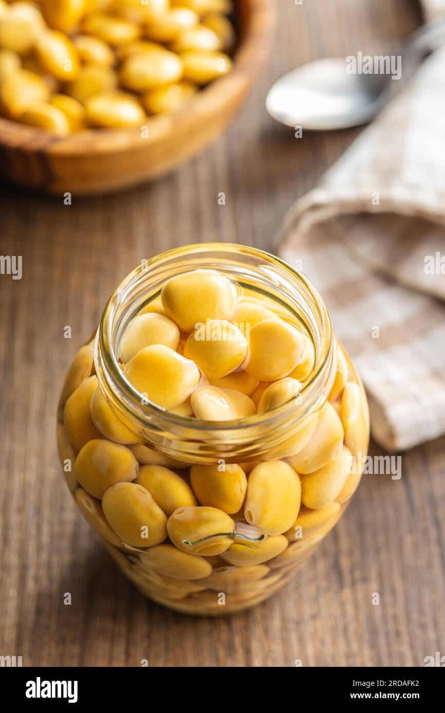 Lupini beans in brine. Pickled lupin in jar on the kitchen table Stock