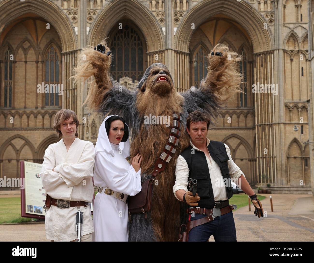 Peterborough, UK. 18th July, 2023. Luke Skywalker, Princess Leia, Chewbacca and Han Solo pose outside Peterborough Cathedral before one of the largest Star Wars private fan collections in the world can be seen in the magnificent Peterborough Cathedral from 19th July. The exhibition, Unofficial Galaxies, at Peterborough Cathedral, includes over 120 exhibits, with a life-sized Land Speeder amongst on show alongside rare Star Wars toys and items. Peterborough, Cambridgeshire, UK. Credit: Paul Marriott/Alamy Live News Stock Photo