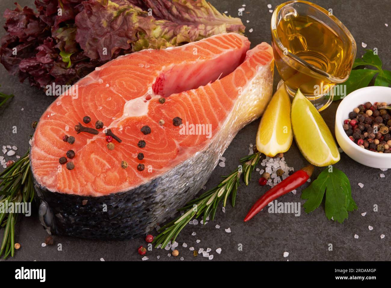 Salmon steak on a black background with spices Stock Photo - Alamy