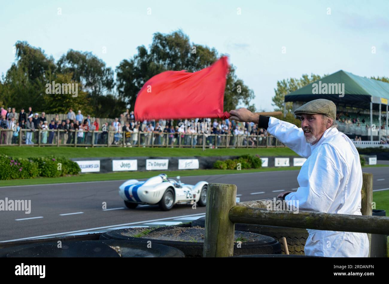 Red flag waved by trackside marshal at the Goodwood Revival vintage motorsport event, West Sussex, UK. Race session stopped Stock Photo