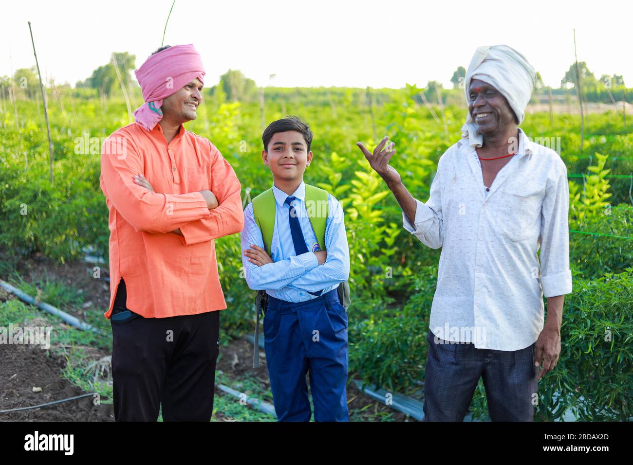 Indian three people standing in farm, farmer and his two son in farm happy family Stock Photo