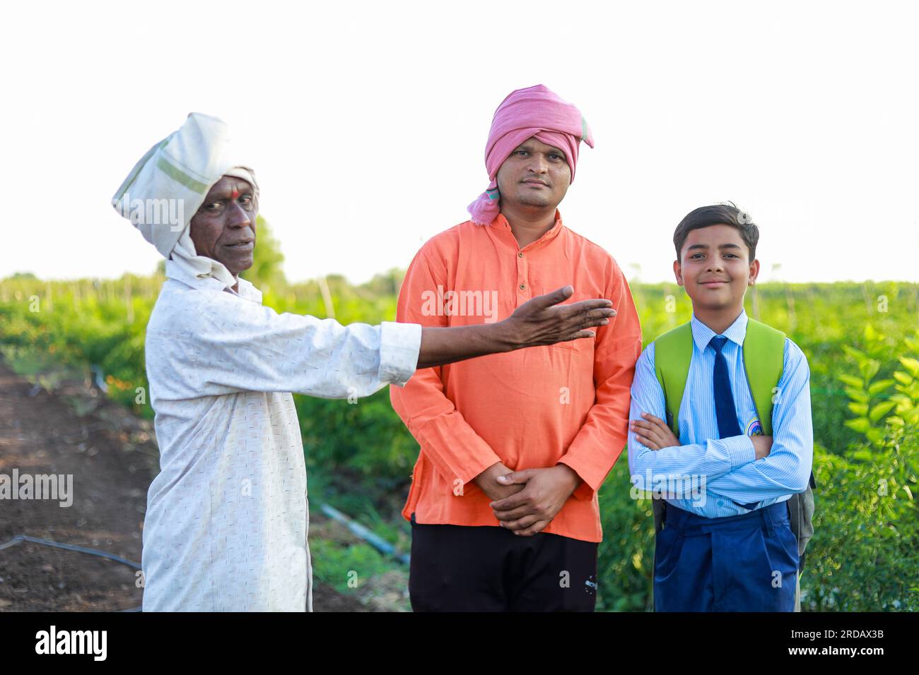 Indian three people standing in farm, farmer and his two son in farm happy family Stock Photo