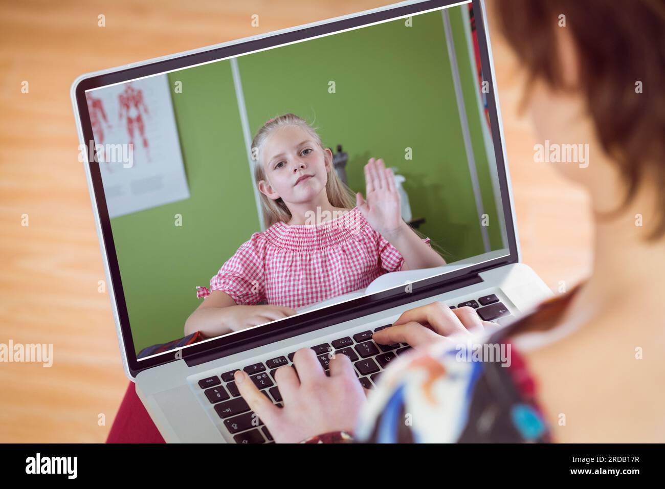 Caucasian female teacher teaching cute girl online over laptop from home Stock Photo