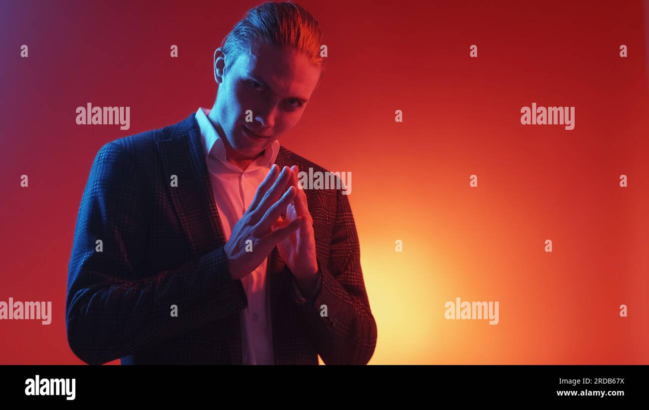 Evil plan exciting expectation neon light sly man Stock Photo
