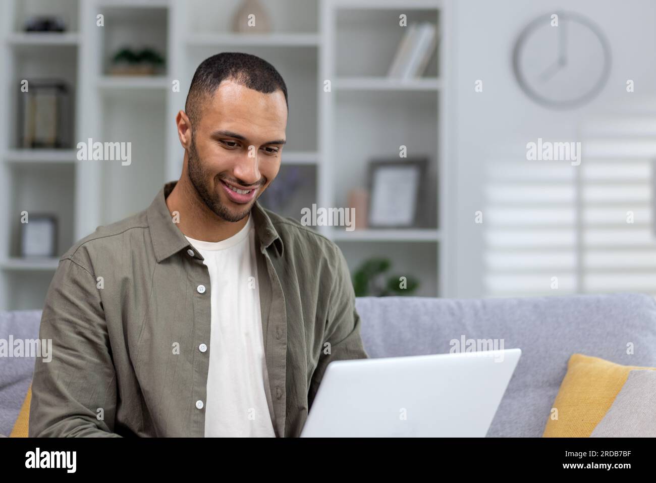 Portrait of young smiling African American male student studying remotely at home with laptop. Close-up photo. Stock Photo